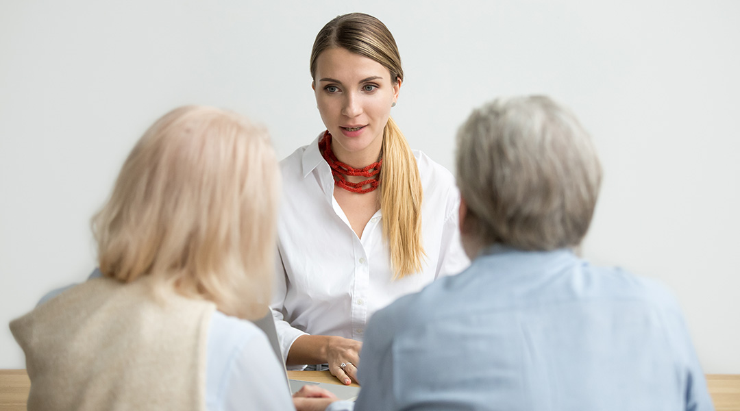 Female financial advisor talking consulting senior aged couple at meeting Female financial advisor talking consulting senior aged couple at meeting